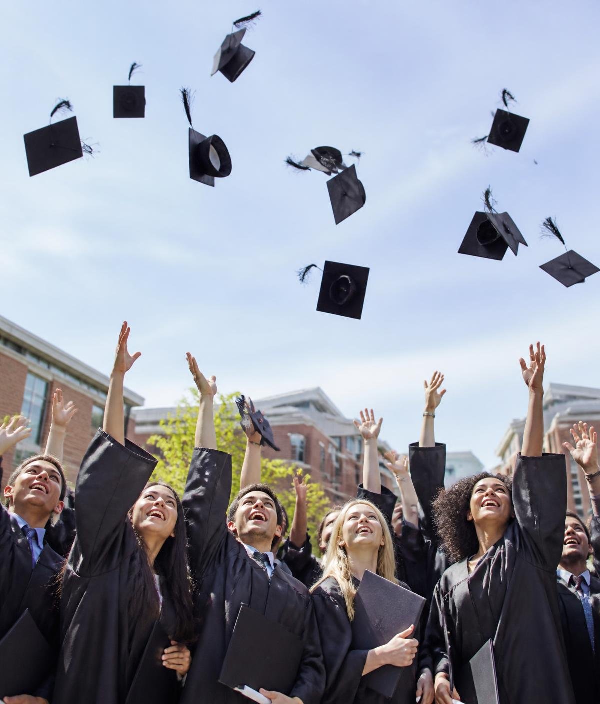 Graduating students throwing their caps in the air